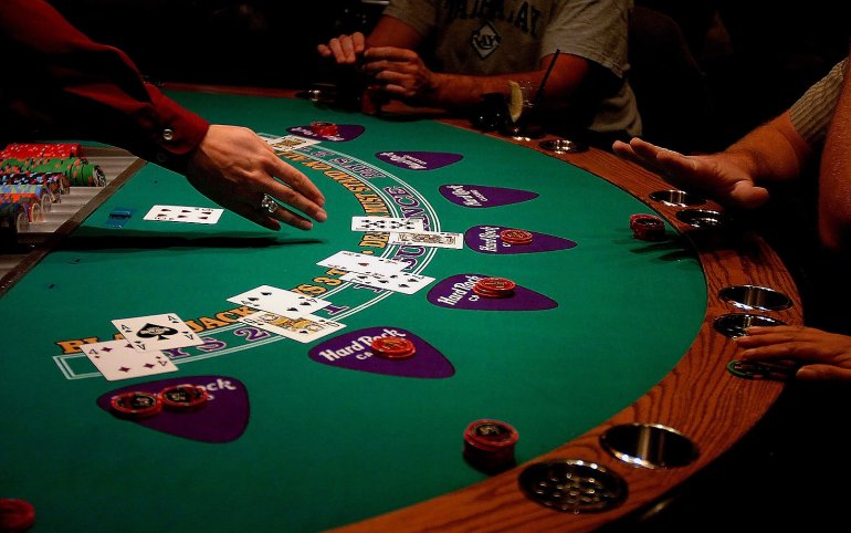 The croupier points to the cards in the Blackjack game
