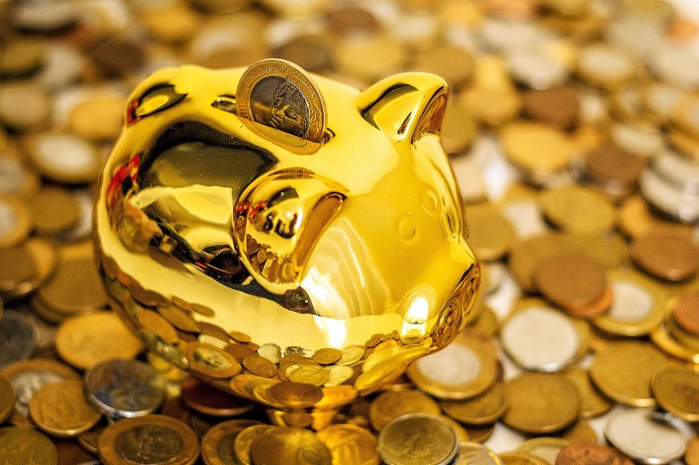 Piggy bank gold pig on the background of a heap of coins