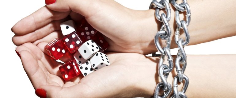Women's hands wrapped in a chain with game cubes in their palms